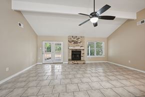 Slidell house for rent - A spacious room with a fireplace and a ceiling fan.