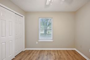 Slidell house for rent - A room with a white door and a window with blinds.
