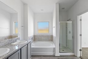 Slidell house for rent - A bathroom with a tub, sink, and shower.