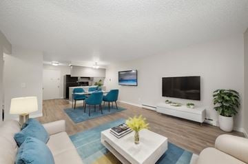 Spokane apartment for rent - a living room with a couch and a table with chairs and a television