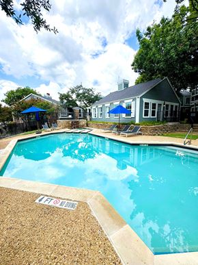 Dallas apartment for rent - A pool with a blue sky and clouds in the background.