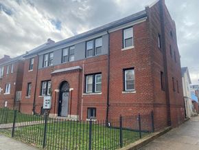 Washington apartment for rent - A red brick building with a black fence in front.