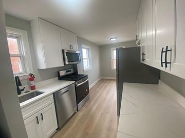 Washington apartment for rent - A kitchen with white cabinets and a black refrigerator.