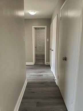 Brantford apartment for rent - A long hallway with white walls and a brick wall in the distance.