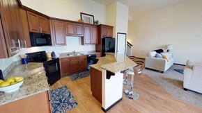 Fargo townhouse for rent - A kitchen with wooden cabinets and a black refrigerator.