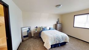 Fargo townhouse for rent - A bedroom with a bed, nightstand, and a window.