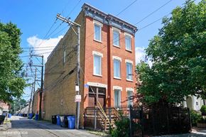 Chicago apartment for rent - A red brick building with a black gate in front.