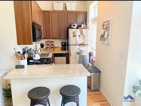 Chicago apartment for rent - a kitchen with a counter and stools in front of a refrigerator