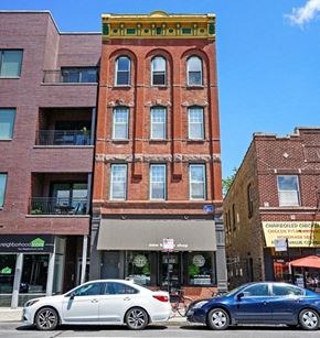 Chicago apartment for rent - a tall brick building with two cars parked in front of it