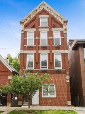Chicago apartment for rent - a tall brick building with a tree in front of it
