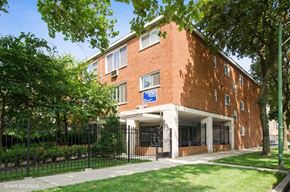Chicago apartment for rent - the front of a brick building with a wrought iron fence