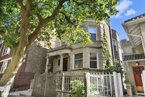 Chicago apartment for rent - a house with a fence and a tree in front of it