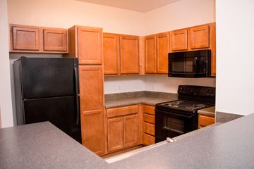 Lynchburg apartment for rent - a kitchen with black appliances and wooden cabinets