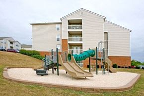 Lynchburg apartment for rent - a childrens playground with a slide in front of an apartment building