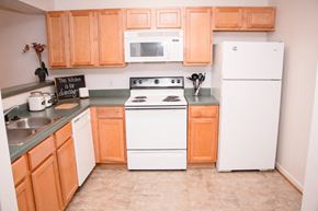 Lynchburg apartment for rent - a kitchen with white appliances and wooden cabinets