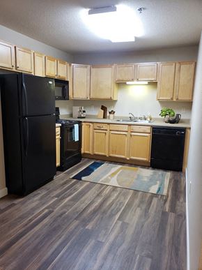 Grand Forks apartment for rent - a kitchen with black appliances and wooden cabinets