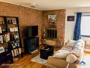Chicago apartment for rent - a living room with a couch and a brick fireplace