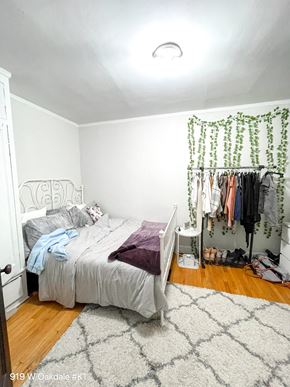 Chicago apartment for rent - a bedroom with a bed and a closet with clothes hanging