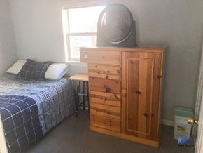 Chicago apartment for rent - a small bedroom with a bed and a chest of drawers