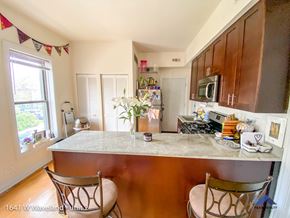 Chicago apartment for rent - a kitchen with a marble counter top and two chairs