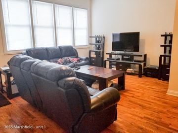 Chicago apartment for rent - a living room with leather furniture and a tv