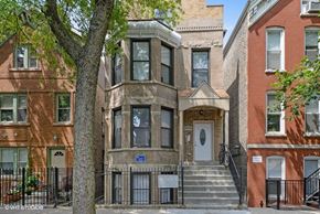 Chicago apartment for rent - A brown house with a white door and a tree in front.
