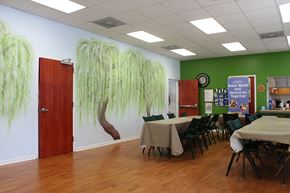 New Orleans apartment for rent - a dining room with tables and chairs and a wall mural of trees