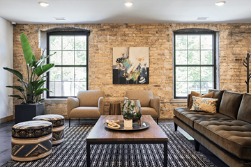 St. Paul apartment for rent - A living room with a brown couch, a coffee table, and a large painting on the wall.