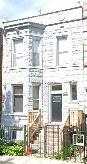 Chicago apartment for rent - A white building with a black door and a black fence.