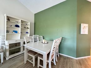 Bradenton house for rent - a dining room with a white table and chairs and a green wall