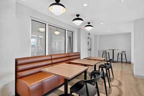 Denver apartment for rent - A modern dining area with brown booths and wooden tables.