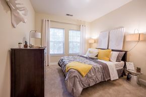 Indianapolis apartment for rent - a bedroom with a bed and a dresser and a window