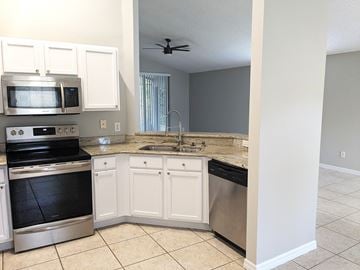 Orlando house for rent - A kitchen with white cabinets and stainless steel appliances.