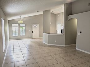 Orlando house for rent - A spacious room with tile flooring and a bar area.