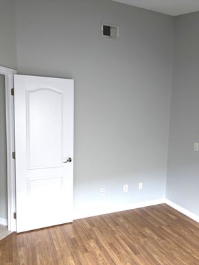 Orlando house for rent - A white door is open to a room with a light switch and a light switch plate on the wall.