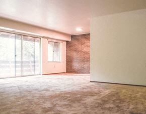 North Versailles apartment for rent - an empty living room with a brick wall and a sliding glass door
