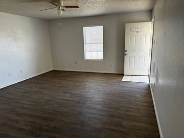 Lubbock apartment for rent - A room with a ceiling fan and a door.