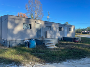 Phenix City apartment for rent - A grey building with a blue barrel in front of it.