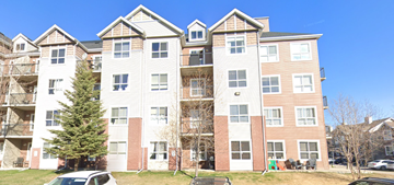 Calgary house for rent - A large apartment building with a tree in front of it.