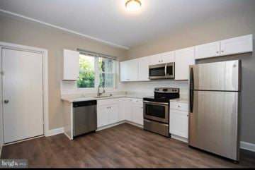 Baltimore house for rent - A kitchen with white cabinets and stainless steel appliances.