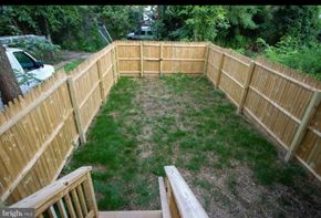 Baltimore house for rent - A backyard with a wooden fence and a grassy area.