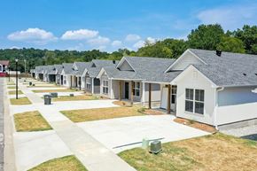Little Rock house for rent - a row of white manufactured homes with grass and trees