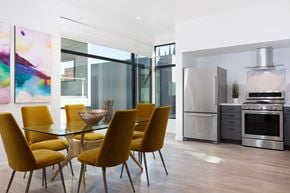 Menlo Ave apartment for rent - A modern kitchen with yellow chairs and a glass table.