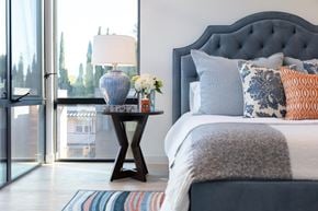 Menlo Ave apartment for rent - A bedroom with a bed, a table with a vase and a lamp.