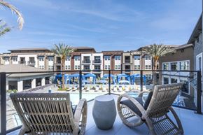 Sacramento apartment for rent - A balcony with two chairs and a table overlooking a pool.