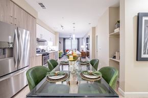 Sacramento apartment for rent - A modern dining room with a glass table and green chairs.