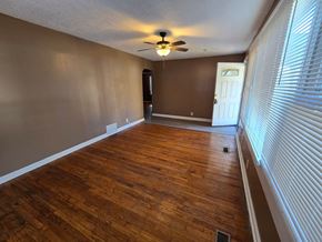 Berkeley house for rent - an empty living room with wood floors and a ceiling fan