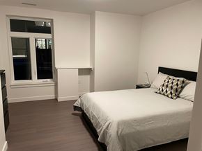 Halifax apartment for rent - A bedroom with a bed, nightstand, and window.