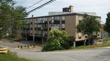Halifax apartment for rent - A large building with a flat roof and a balcony on the second floor.