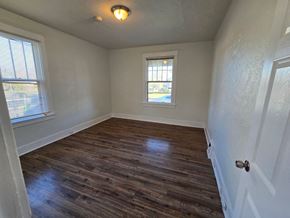 Saint Louis house for rent - an empty living room with wooden floors and a window